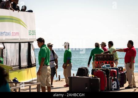 San Pedro, Ambergris Caye, Belize - 18 novembre, 2019. Les touristes descendent de water taxi bateau et accueillis par des porteurs à San Pedro dans la matinée après Banque D'Images