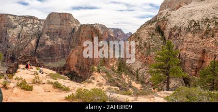 Family sitting on bluff donnant sur Angel's Landing randonnée pédestre, Zion National Park, Utah, USA, printemps Banque D'Images