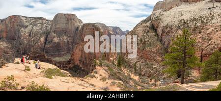 Family sitting on bluff donnant sur Angel's Landing randonnée pédestre, Zion National Park, Utah, USA, printemps Banque D'Images