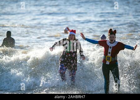 25 décembre 2019 : Brighton, Royaume-Uni. 25 décembre 2019. Des centaines de personnes se rassemblent sur la plage de Brighton pour leur journée annuelle de Noël nager. En dépit de l'augmentation des problèmes de sécurité et du Conseil les grandes vagues de la mer, plusieurs nageurs ont pris part cette année à la trempette de Noël au large de la plage de Brighton dans leurs bikinis, shorts de natation, et Santa Claus Crédit : Matt Duckett tenues/IMAGESLIVE/ZUMA/Alamy Fil Live News Banque D'Images