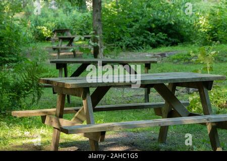 Tables de pique-nique dans une rangée sur un terrain de camping pendant la saison estivale Banque D'Images