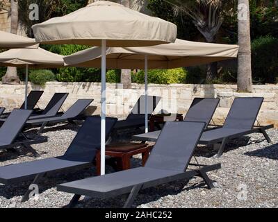 Parasols et chaises longues pour se détendre sur la plage, Pissouri, Chypre Banque D'Images