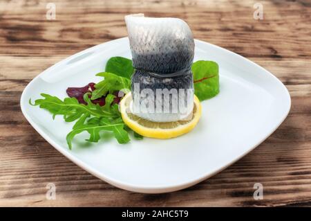 Hareng mariné avec salade mixte sur table en bois Banque D'Images