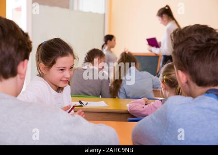 Portrait des enfants discuter quelque chose pendant la leçon à l'école Banque D'Images