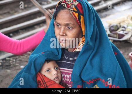 Winter Cold tejgoan gare,21dec2019 tejgoan gare stationDhaka Bangladesh.une femme âgée tient le bébé dans ses bras et enveloppe le bébé avec une feuille pour le protéger du froid.Nazmul Islam/alamy stock Live news Banque D'Images