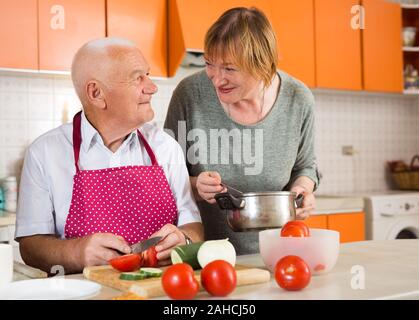 Heureux homme âgé et woman together in kitchen Banque D'Images