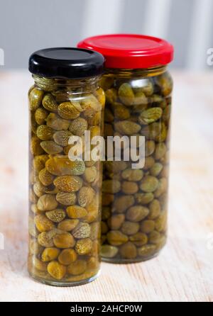 Câpres au vinaigre dans un bocal en verre sur la table en bois Banque D'Images
