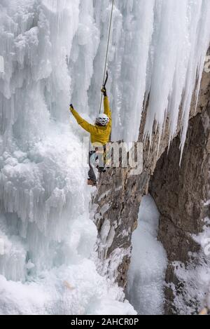 Le parc national Banff, Alberta, Canada - le 15 décembre 2019 : un grimpeur sur glace masculin solo travaille son chemin jusqu'frozen chutes supérieures à Johnston Canyon Banque D'Images