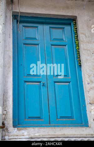 Porte bleu vif dans une ruelle dans la vieille ville de Delhi en Inde. Piments verts attachés à un fil accroché à conserver à l'écart Alakshmi Jyestha, ou Banque D'Images