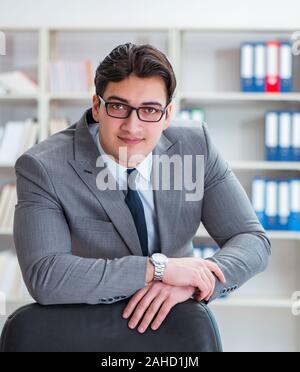 Le jeune homme d'affaires travaillant dans le bureau Banque D'Images