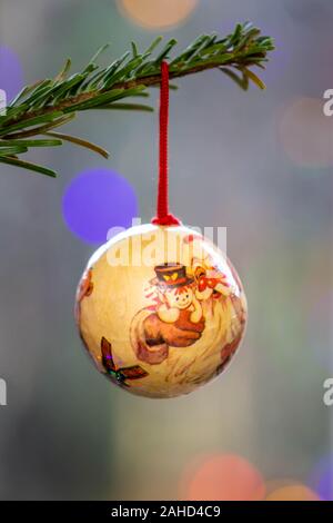 Fait main unique bauble hanging sur la branche d'un arbre de Noël du flou fairy lights dans l'arrière-plan Banque D'Images