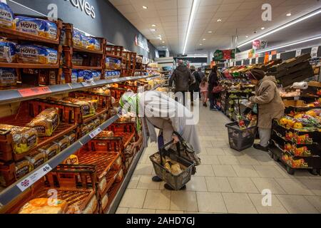 Consommateurs d'épicerie dans un supermarché Lidl pour leur repas de fête et le vin avant le jour de Noël, Angleterre, Royaume-Uni Banque D'Images