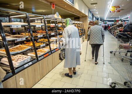 Consommateurs d'épicerie dans un supermarché Lidl pour leur repas de fête et le vin avant le jour de Noël, Angleterre, Royaume-Uni Banque D'Images