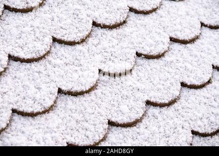 Modèle d'un gros plan d'un toit à tuiles plane recouverte d'une fine couche de neige. Vu en Allemagne en décembre Banque D'Images