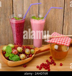 Smoothie aux petits fruits, groseilles, groseilles à maquereau et le miel sur une surface en bois Banque D'Images