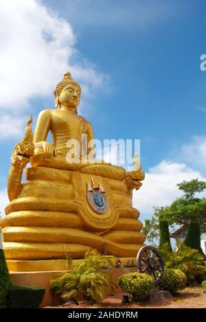 Une statue en or de Bouddha assis, flanqué de deux serpents Naga en Thaïlande. Banque D'Images