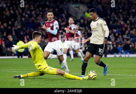 Marcus Rashford Manchester United (à droite) tire la balle passé Burnley gardien Nick Pope à marquer son deuxième but de côtés du jeu pendant le premier match de championnat à Turf Moor, Burnley. Banque D'Images