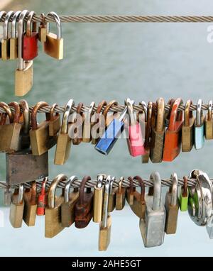 Rusty colorés cadenas laissés par sweethearts verrouillé sur un bridge Banque D'Images