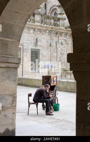 Un photographe de rue avec un vieux voir l'appareil photo attend pour les sujets à Praza da Inmaculada à Santiago de Compostela, Espagne. La ville est le te Banque D'Images