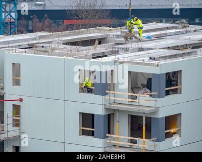 Builders avec grue à étages de construction maison. Hiver ou automne fond. Les travailleurs des constructeurs avec grue sur un appartement maison. Sous ciel bleu du concept d'entreprise. Banque D'Images