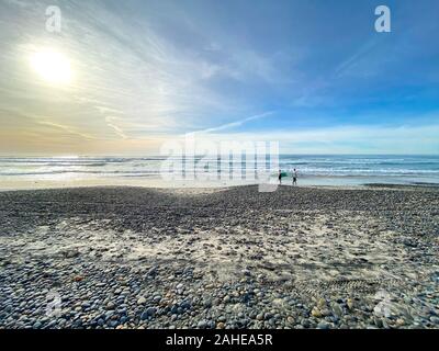 Balades surfer avec leur conseil sur Torrey Pines State Beach avant le coucher du soleil, crépuscule plage côtière situé dans le quartier de San Diego, en Californie. Décembre 12th, 2019 Banque D'Images