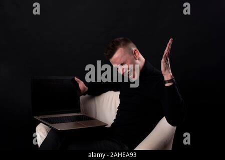 J'ai gagné. Large succès homme heureux de célébrer d'être un gagnant avec ordinateur portable. Image dynamique de l'homme de race blanche sur fond noir modèle studio. La victoire, de Banque D'Images