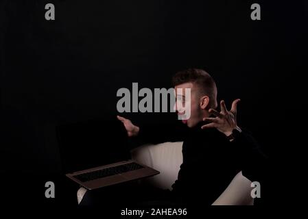 J'ai gagné. Large succès homme heureux de célébrer d'être un gagnant avec ordinateur portable. Image dynamique de l'homme de race blanche sur fond noir modèle studio. La victoire, de Banque D'Images