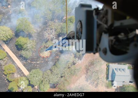 Une antenne de l'approvisionnement en eau seau plein d'eau en vertu de l'attaché d'un hélicoptère CH-47 Chinook de la 2-149e, TXARNG s'élève, d'un lac ou de la rivière pour revenir à un incendie près de propriété résidentielle, à proximité de Bastrop, Texas, le 6 septembre 2011. Les équipages de la Garde nationale du Texas a lancé hors de la Austin Army Aviation mondial à lutter contre les incendies. Ils font partie d'un groupe de réponse qui comprend le département américain de l'Agriculture des forêts qui en cas de besoin à des missions d'observation des mouches antenne directe des opérations de lutte contre les incendies. Depuis 1975, le ministère de l'Agriculture et Ministère de l'Intérieur ont eu un Banque D'Images