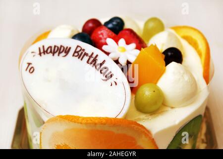 Un gâteau aux fruits avec une carte au chocolat blanc pour toute célébration comme anniversaire, noël, anniversaire, mariage, Saint Valentin, retraite etc Banque D'Images