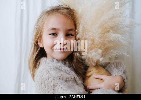 Portrait of a little girl hugging coconut vase avec bouquet de céréales en elle. Banque D'Images