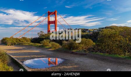 Panorama de la San Francisco Golden Gate Bridge à Marin Headlands Californie se reflétant dans une flaque d'eau après la pluie avec des nuages en arrière-plan Banque D'Images