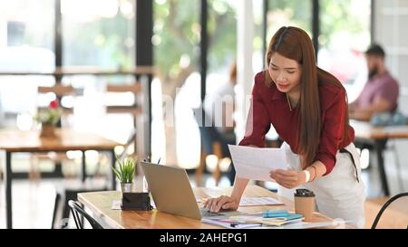 Jeune femme créative guide couleur sélectionnée avec l'ordinateur portable sur l'espace de travail de l'artiste. Banque D'Images