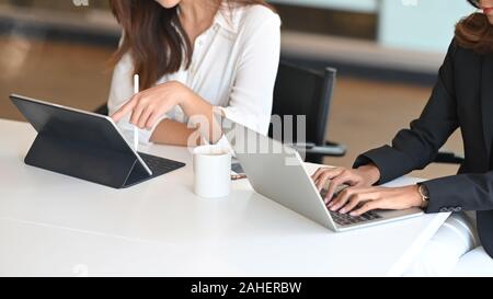 Portrait de femme tourné deux ils travail avec ordinateur portable et tablette sur table office. Banque D'Images