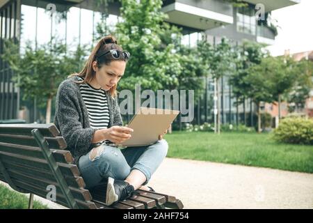 La fille utilise un ordinateur. Elle a lu de mauvaises nouvelles ou est-elle grave ou contrariés. Banque D'Images