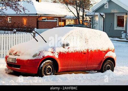 Umea, Suède Norrland - décembre 5, 2019 : une voiture neige rouge se trouve dans le parc de stationnement Banque D'Images