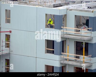 Builders avec grue à étages de construction maison. Hiver ou automne fond. Les travailleurs des constructeurs avec grue sur un appartement maison. Sous ciel bleu du concept d'entreprise. Banque D'Images