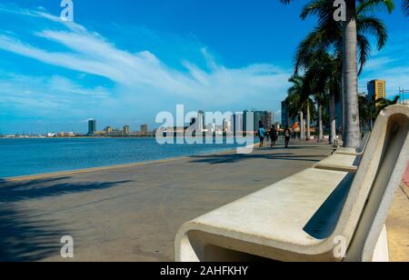 Luanda, Angola - 15 décembre 2019: Les gens marchant une journée ensoleillée à la baie de Luanda. Illustration éditoriale. Banque D'Images