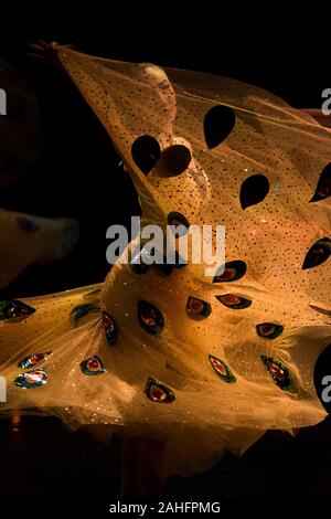Asian Woman in belle robe jaune à motifs de la danse et de tourner dans le cadre d'une célébration de la culture chinoise au Canada, le visage partiellement visible Banque D'Images