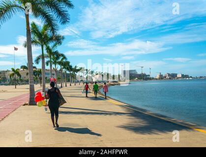 Luanda, Angola - 15 décembre 2019: Les gens marchant une journée ensoleillée à la baie de Luanda. Illustration éditoriale. Banque D'Images