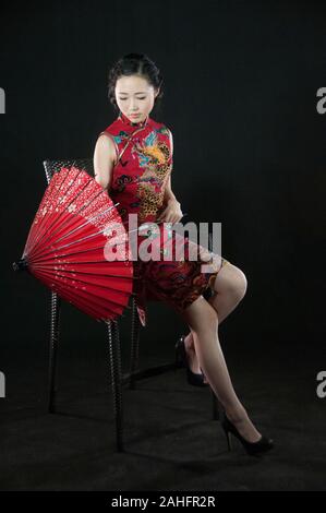 Femme d'origine asiatique, dans diverses poses wearing traditional Chinese cheongsam qipao ou un style traditionnel Banque D'Images