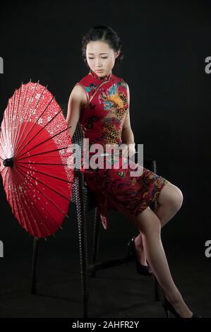 Femme d'origine asiatique, dans diverses poses wearing traditional Chinese cheongsam qipao ou un style traditionnel Banque D'Images