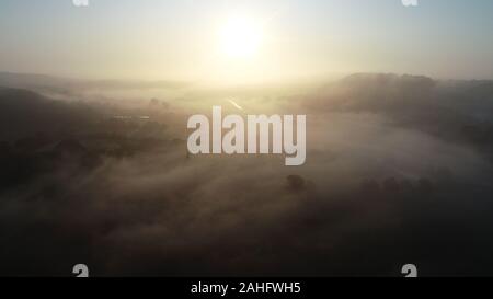 Lever du soleil et le brouillard dans la vallée de la rivière, Ravning Vejle, Danemark Banque D'Images