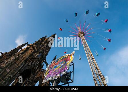 Princes Street Gardens, Édimbourg, Écosse, Royaume-Uni. 29 décembre 2019. Les fêtes de Noël : du soleil dans le centre-ville avec la star flyer fairground ride décoller dans le ciel à côté du Scott monument Banque D'Images