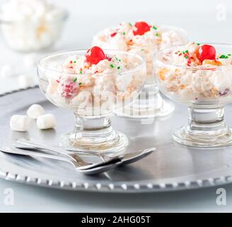 Un gros plan de coupes de verre rempli de salade Ambrosia sur un plateau de service en métal Banque D'Images