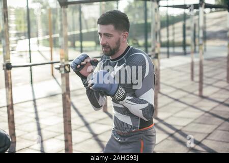 Boxer barbu debout au terrain de sport et l'exécution des positions de boxe Banque D'Images