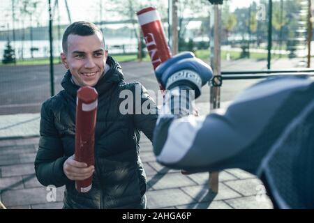 Formateur optimiste smiling while ayant la formation avec son boxer Banque D'Images