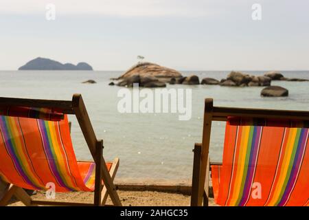 En bois coloré, deux chaises de plage face à la mer avec de petites îles sur l'arrière-plan à Koh Phangan, Thaïlande. Vacances d'été concept chill out Banque D'Images