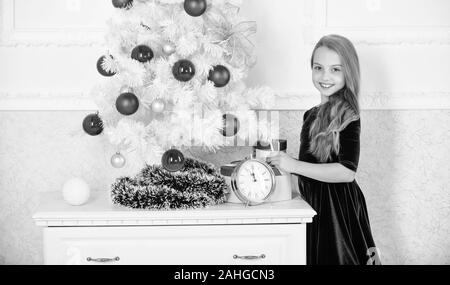 Dernières préparations. Enfant célébrer Noël à la maison. Jour préféré de l'année. Célébration de Noël. Obtenir incroyablement excité à propos de noël. Fille de l'arbre de Noël pour enfants près de minuit réveil d'attente. Banque D'Images