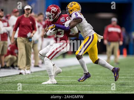 28 décembre 2019 : Texas wide receiver Nick Basquine (83) s'exécute avec la balle comme la sécurité de la LSU Kary Vincent Jr. (5) poursuit en NCAA Football action de jeu entre l'Oklahoma Sooners et la LSU Tigers au stade Mercedes-Benz à Atlanta, Géorgie. Défait LSU Oklahoma 63-28. John Mersits/CSM Banque D'Images