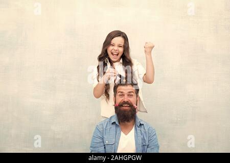 Changer de coiffure. Créer drôle de coiffure. Enfant faisant hairstyle styling père barbe. Être parent signifie présenter pour leurs intérêts. Avec bonne dose d'ouverture n'importe quel père peut exceller à sensibiliser le jeune fille. Banque D'Images